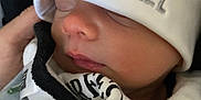 Zachary is registered to the contest to win money with this photo: newborn, baby, sleeping, hat, clothing, face, infant, closeup, peaceful, cozy, soft_lighting, portrait, child, cute, person, sleep, headwear, warm, rest, newborn_clothes