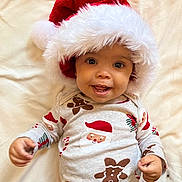 Avery is registered to the contest to win money with this photo: baby, child, santa_hat, holiday_pajamas, smiling, lying_down, festive, cute, infant, red_and_white, striped_pants, gingerbread_man, candy_cane, soft_blanket, portrait, happy, indoors, holiday_theme, close_up, face