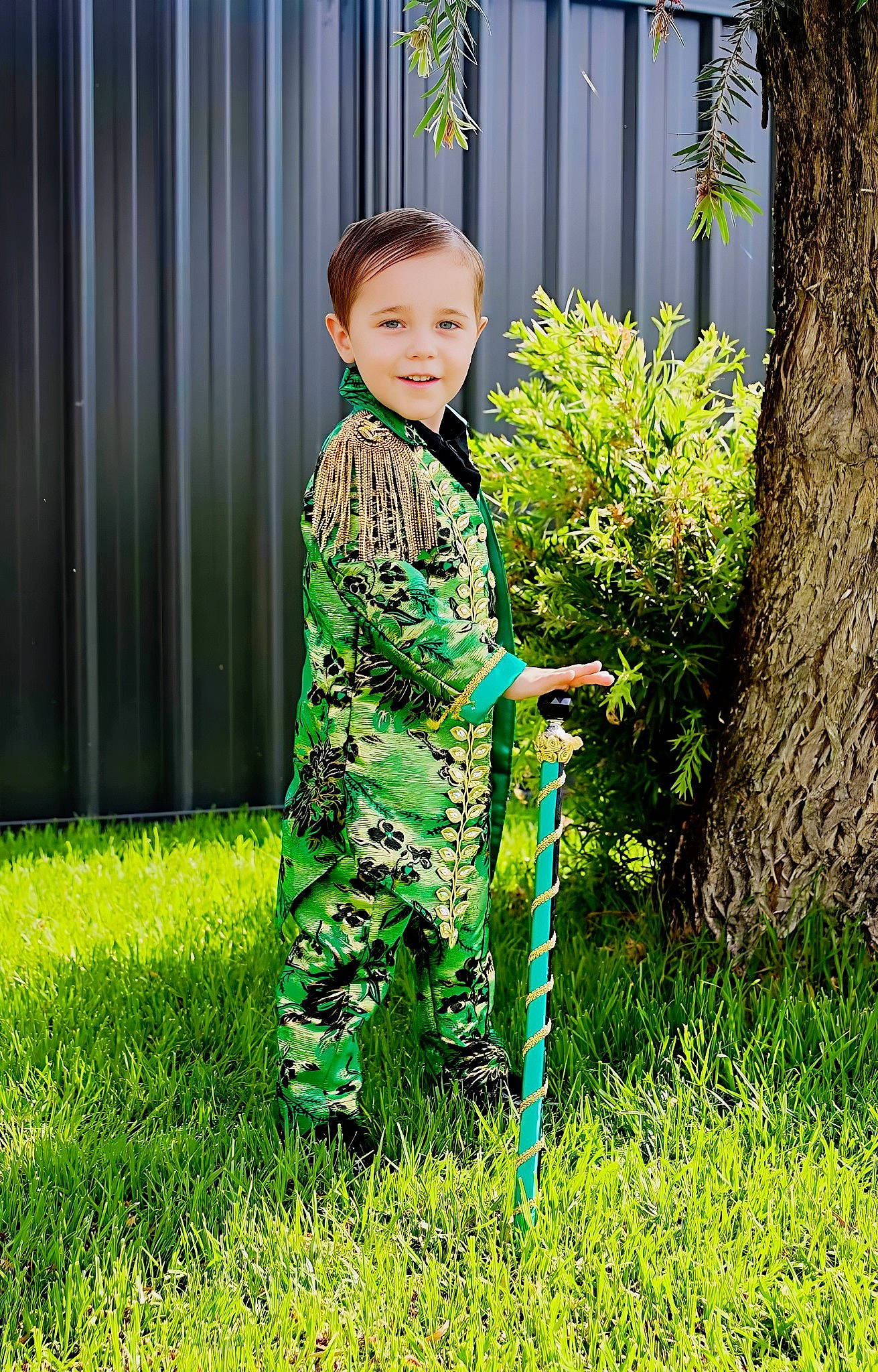 Aidan is registered to the contest to win money with this photo: baby_toddler_clothing, child, electric_blue, formal_wear, fun, garden, grass, grass_family, happy, joy, lawn, pattern, people_in_nature, person, plant, shrub, sleeve, smile, terrestrial_plant, toddler