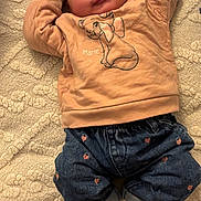 Nourhane a rejoint le concours — aidez-le/la à gagner de superbes lots ! apparel, baby, blanket, cartoon, child, clothing, cozy, cute, face, footwear, happy, indoor, infant, jeans, lying_down, patterned, person, shoes, smiling, sweatshirt