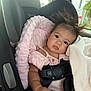 baby, child, car_seat, blanket, pink, hair, wild_hair, infant, seatbelt, toddler, soft_texture, cute, indoors, car_interior, curious_expression, clothing, safety, portrait, seat, resting