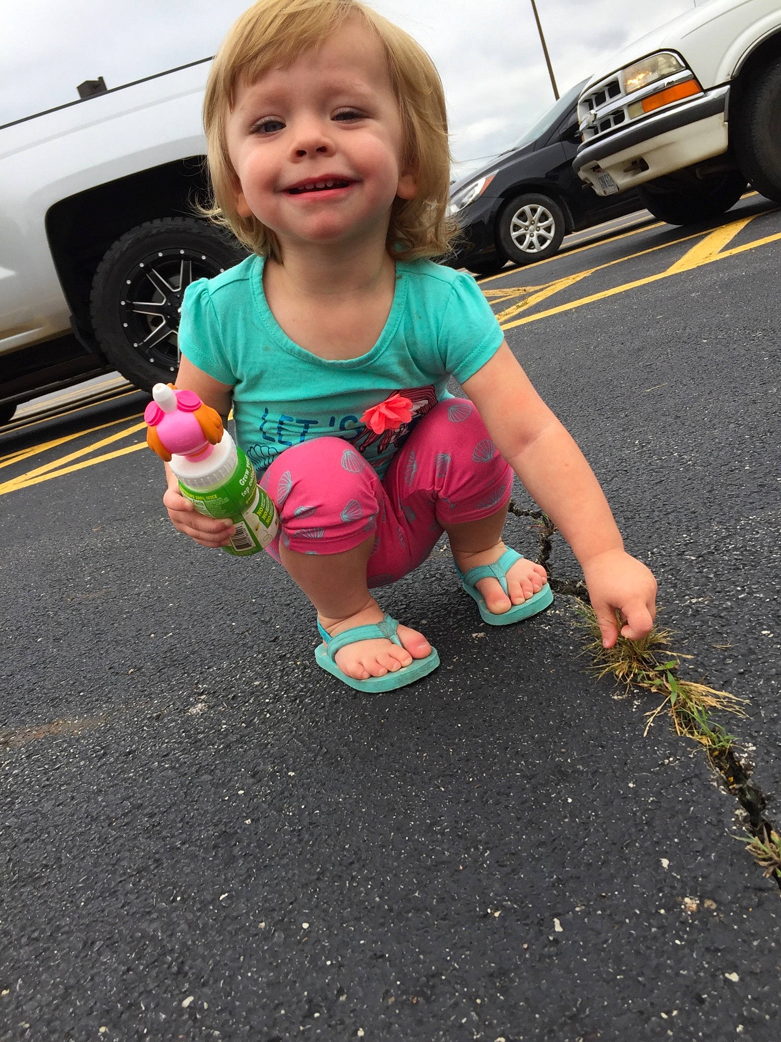 Skylah joined the competition — help win amazing prizes! asphalt, car, child, day, finger, footwear, fun, girl, green, hand, joy, leg, person, pink, play, recreation, shoe, sitting, smile, toddler