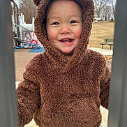 Koa is registered to the contest to win money with this photo: bench, cap, clothing, coat, face, furniture, happy, hat, head, hood, hoodie, jacket, knitwear, outdoors, person, photography, portrait, smile, sweater, sweatshirt