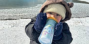 Koa is registered to the contest to win money with this photo: baby, cap, clothing, coat, cream, dessert, face, food, glove, hat, head, ice, jacket, nature, outdoors, pants, person, photography, portrait, soil