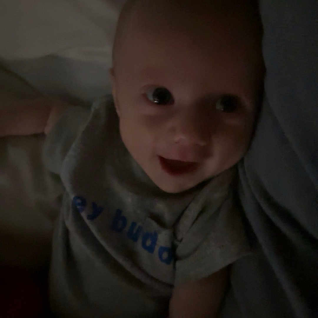 Bentley is registered to the contest to win money with this photo: baby, bed, bedroom, bodypart, clothing, couch, cushion, face, finger, furniture, hand, happy, head, homedecor, newborn, person, photography, portrait, smile, t_shirt