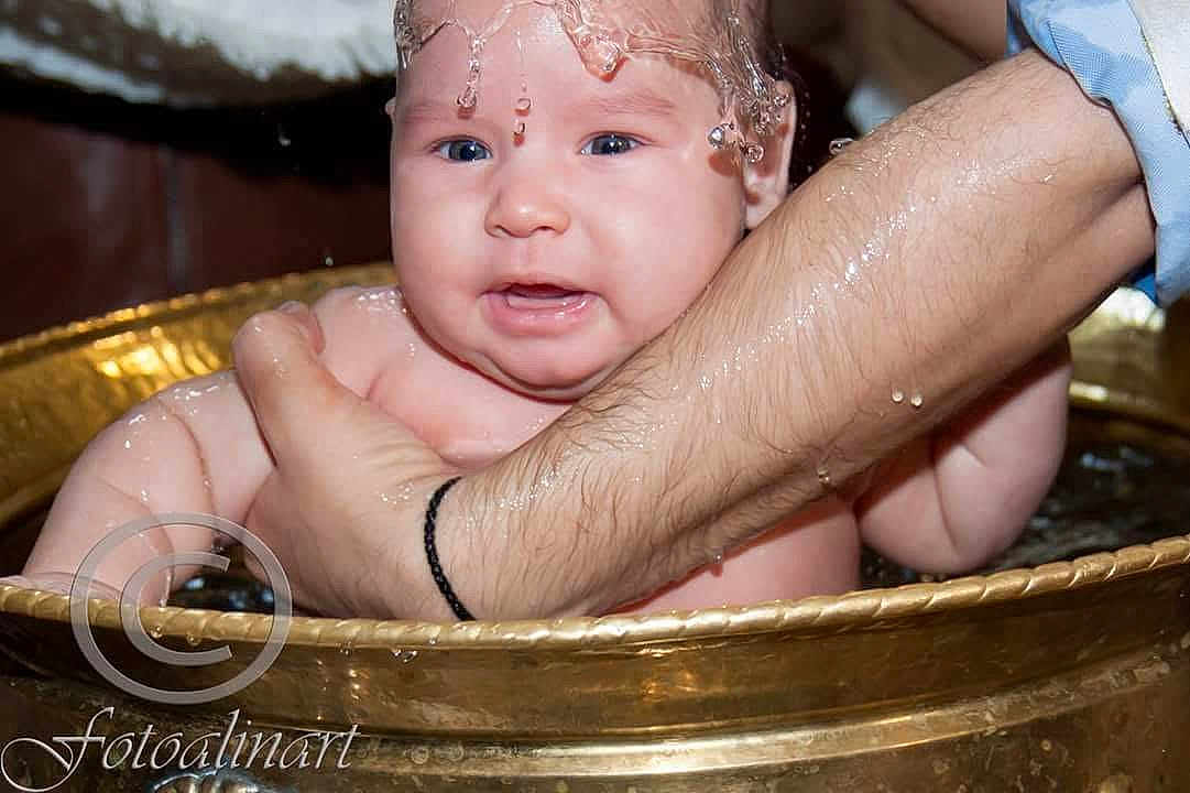 Davide participe au concours pour gagner de l'argent avec cette photo : baby, child, water, arm, golden_basin, splash, wet_skin, support, infant, bath, closeup, human, person, skin, hand, blue_eyes, expression, droplets, adult, holding