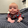 Roczen is registered to the contest to win money with this photo: baby, child, infant, face, eyes, shirt, patterned_clothing, bed, blanket, texture, indoor, portrait, cute, hands, skin, expression, room, furniture, soft_focus, lying_down