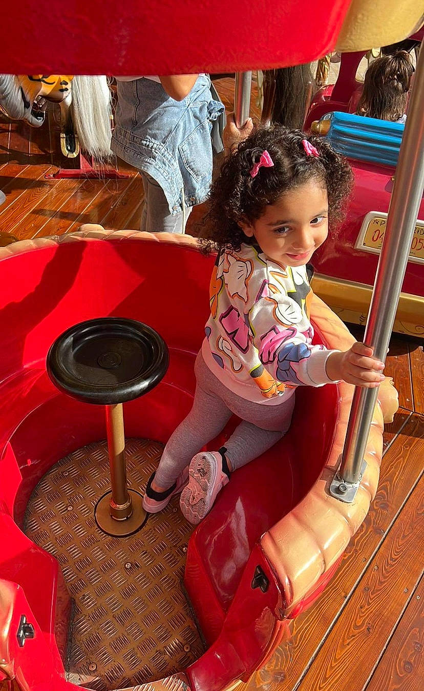 Nour participe au concours pour gagner de l'argent avec cette photo : baby_toddler_clothing, bag, child, fun, hat, human_leg, joy, leg, leisure, magenta, person, pink, red, sandal, shoe, shorts, sitting, skin, sneakers, thigh
