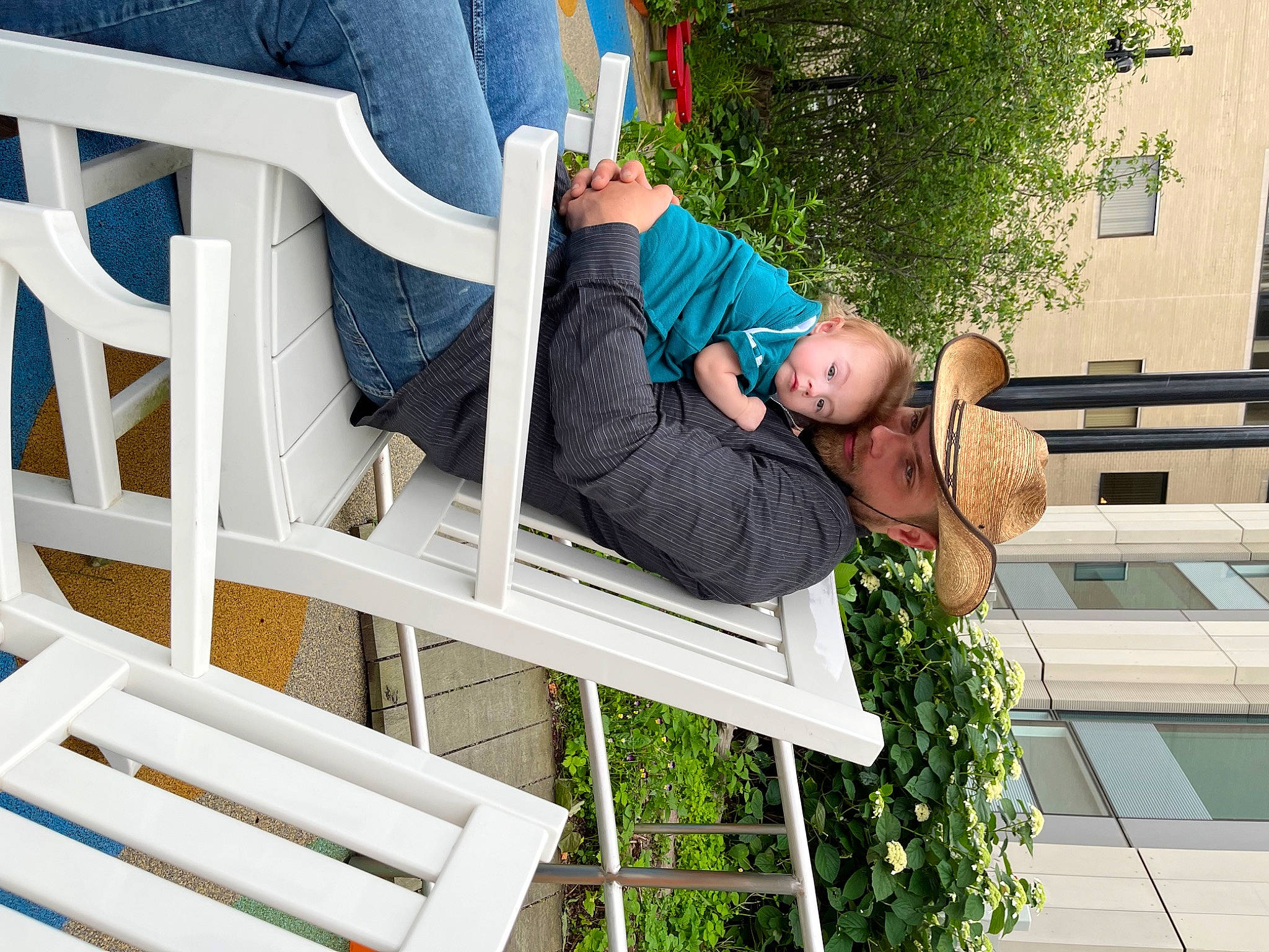 Dyani is registered to the contest to win money with this photo: blue, child, comfort, fun, glasses, grass, green, headwear, jeans, leg, leisure, outdoor_furniture, person, public_space, shoe, shorts, sitting, sneakers, summer, t_shirt