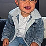 Kayden participe au concours pour gagner de l'argent avec cette photo : child, toddler, smiling, denim_jacket, jeans, white_shirt, sitting, indoor, window, couch, happy, teeth, hand, portrait, face, cute, fleece, cozy, flash_photography, young