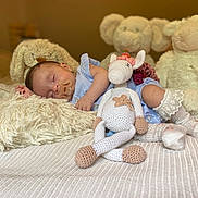 Anna a rejoint le concours — aidez-le/la à gagner de superbes lots ! baby, sleeping, pacifier, stuffed_animal, crocheted_toy, unicorn, plush, pillow, bed, blanket, socks, blue_clothing, soft_toys, child, indoor, cozy, cute, rest, infant, nursery
