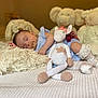baby, sleeping, pacifier, stuffed_animal, crocheted_toy, unicorn, plush, pillow, bed, blanket, socks, blue_clothing, soft_toys, child, indoor, cozy, cute, rest, infant, nursery