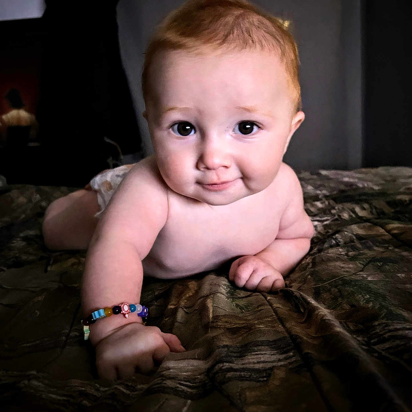 Oliver is registered to the contest to win money with this photo: arm, baby, bedspread, bracelet, child, closeup, crawling, curious, cute, expression, face, hand, indoors, infant, light, person, portrait, skin, smile, young