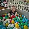 Anthony joined the competition — help win amazing prizes! baby, child, ball_pit, colorful_balls, crib, nursery, indoor, playtime, toys, black_shirt, flooring, furniture, person, infant, smiling, cute, baby_toys, home, play_area, young_child