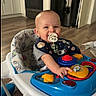 Anthony is registered to the contest to win money with this photo: baby, pacifier, walker, toy, kitchen, floor, smile, happy, child, indoor, play, clothing, bib, furniture, appliance, flooring, person, cute, infant, home