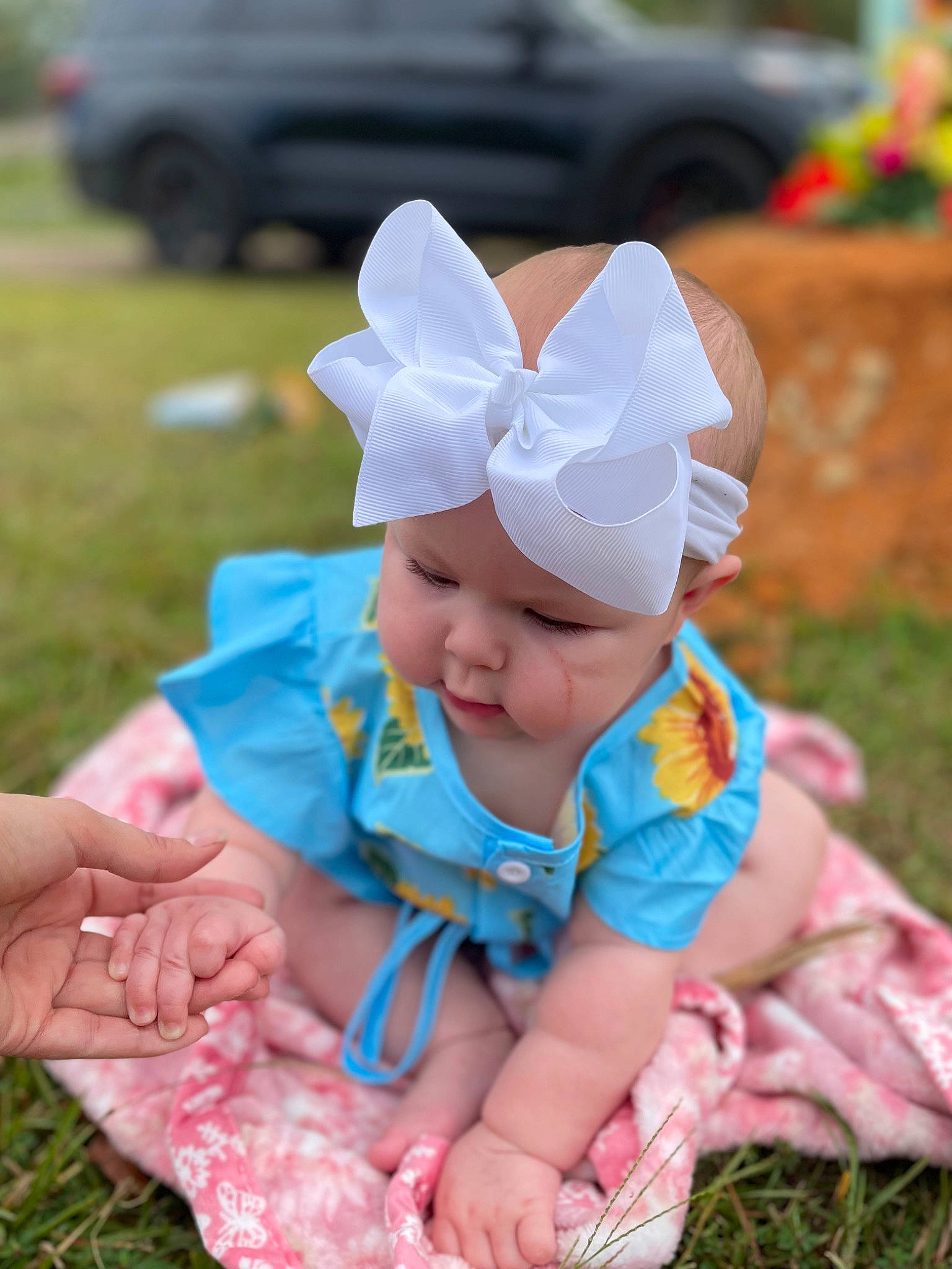 Averi is registered to the contest to win money with this photo: baby, baby_toddler_clothing, cap, child, costume_hat, fashion_accessory, fun, grass, happy, hat, headband, headwear, person, personal_protective_equipment, pink, plant, recreation, sitting, smile, summer