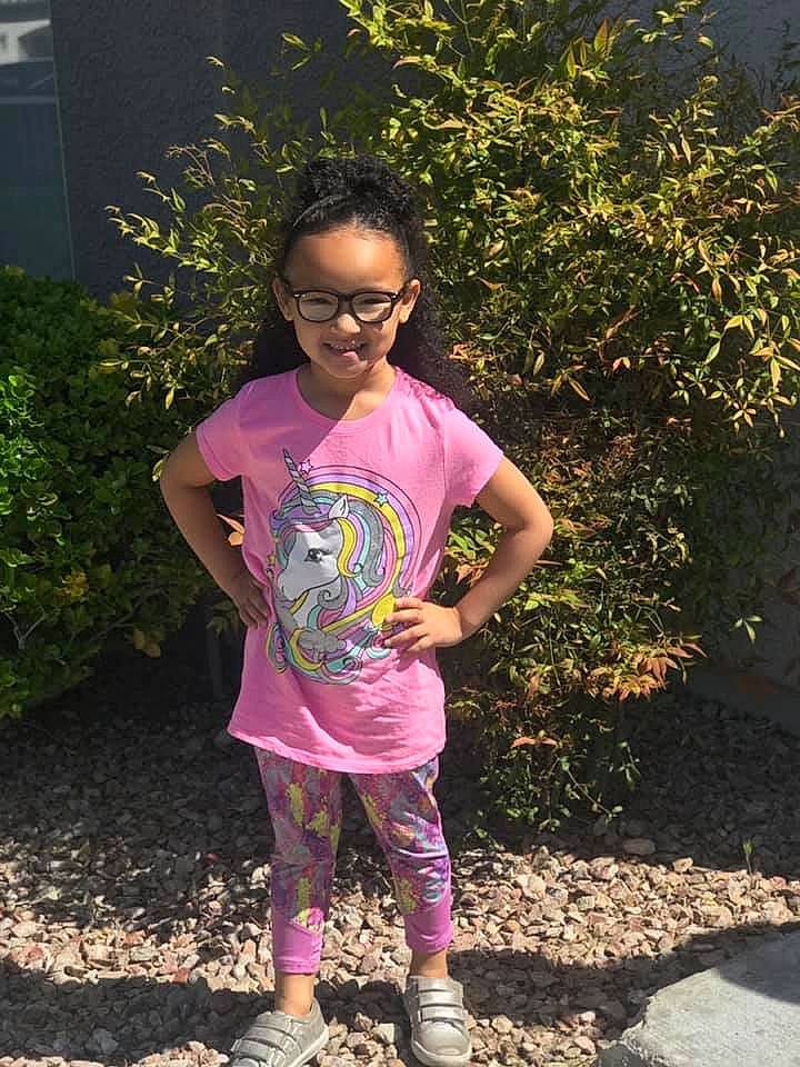 Delanie is registered to the contest to win money with this photo: adaptation, child, footwear, fun, garden, glasses, person, pink, plant, purple, shoe, smile, soil, t_shirt, tree, vacation