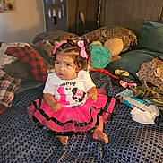 Za'Liyah joined the competition — help win amazing prizes! toddler, child, pink_bow, tutu_skirt, curly_hair, bed, pillows, stuffed_toy, blanket, clothing, indoor, baby_wipes, patterned_bedspread, decor, hair_bows, footwear, sitting, cute, celebration, room