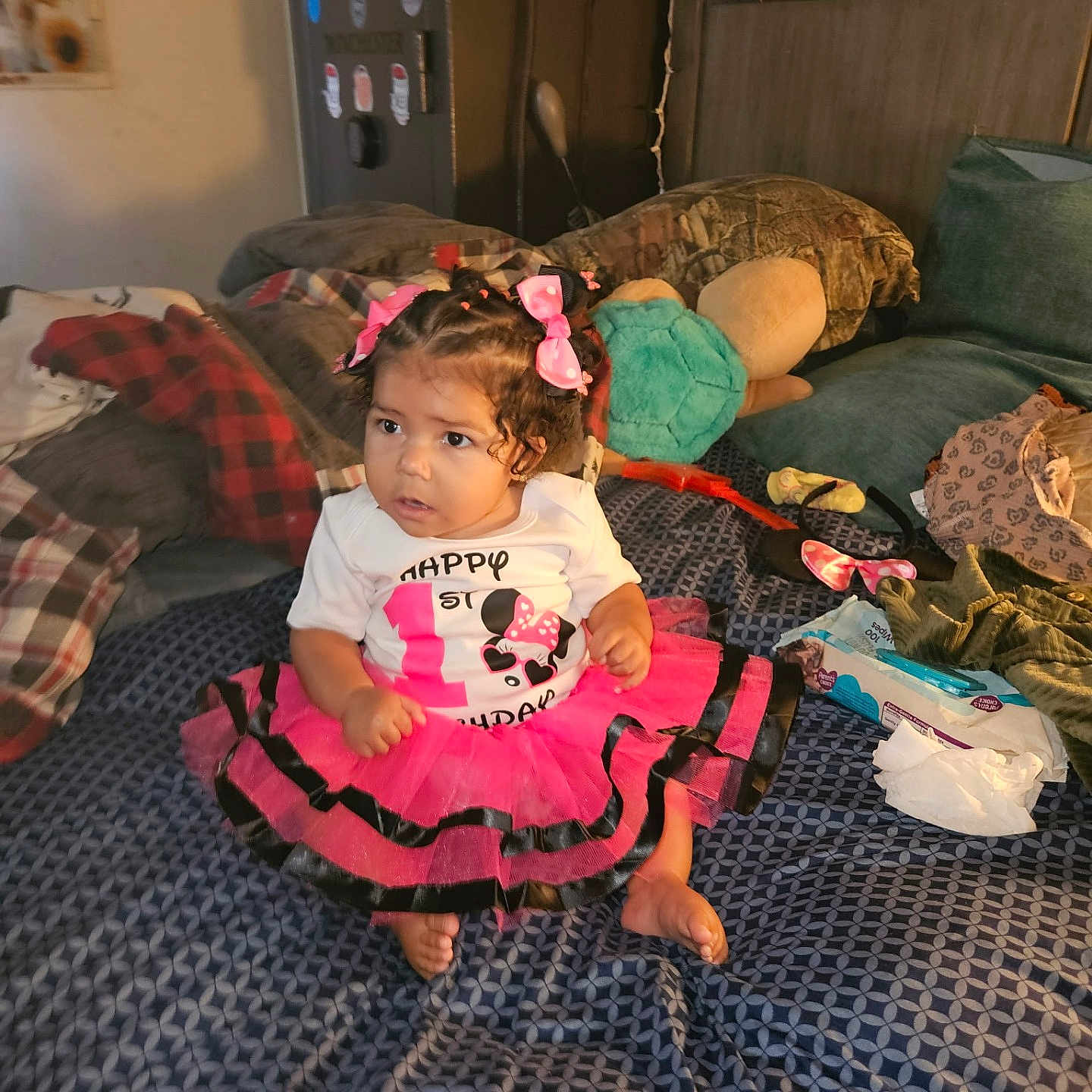 Za'Liyah joined the competition — help win amazing prizes! baby_wipes, bed, blanket, celebration, child, clothing, curly_hair, cute, decor, footwear, hair_bows, indoor, patterned_bedspread, pillows, pink_bow, room, sitting, stuffed_toy, toddler, tutu_skirt