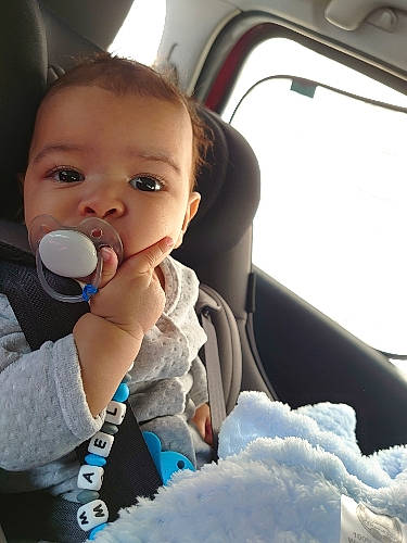 Tymael a rejoint le concours — aidez-le/la à gagner de superbes lots ! auto_part, automotive_exterior, baby, baby_toddler_clothing, car, car_seat, child, drinkware, family_car, fun, gesture, happy, head_restraint, nose, person, plastic_bottle, steering_wheel, thumb, toddler, vehicle_door