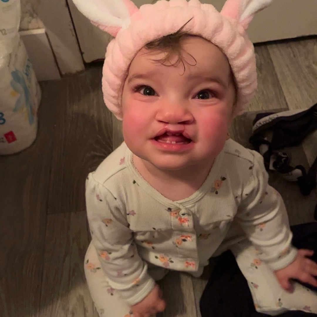 Rosalie joined the competition — help win amazing prizes! animal, baby, bird, bonnet, cap, clothing, costume, dress, face, glove, hardwood, hat, head, indoors, pajamas, pants, person, photography, portrait, wood