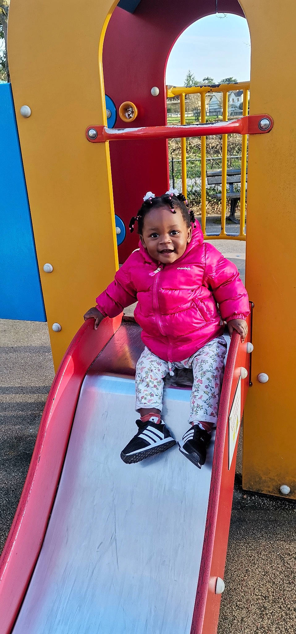 Kêmaya participe au concours pour gagner de l'argent avec cette photo : child, city, facial_expression, fun, happy, leisure, magenta, outdoor_play_equipment, people, person, pink, playground, playground_slide, purple, recreation, red, shelf, smile, standing, toddler