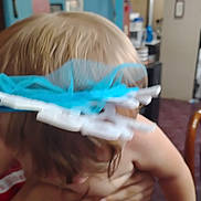 Sophia is registered to the contest to win money with this photo: child, indoor, blurry, person, hair, hand, room, furniture, blue, white, holding, skin, head, adult, background, household, object, clothing, arm, home