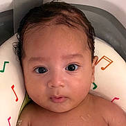Angel is registered to the contest to win money with this photo: baby, child, face, water, bath, neck_float, musical_notes, wet_hair, skin, infant, closeup, portrait, cute, relaxing, indoors, young, person, expression, looking, toddler