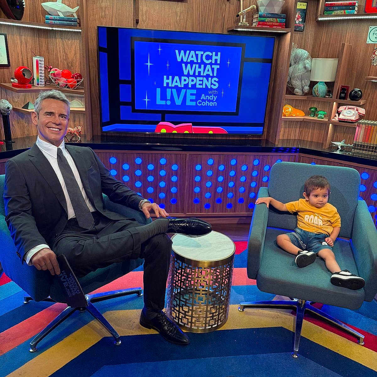 Priyansh is registered to the contest to win money with this photo: book, bookshelf, carpet, chair, child, colorful, decor, denim_shorts, indoors, man, modern, show, smile, studio, suit, table, television, tie, toddler, yellow_shirt
