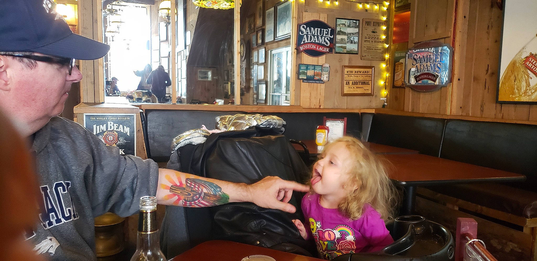 Aria is registered to the contest to win money with this photo: barware, chair, drink, drinkware, event, fashion_accessory, fun, headwear, leisure, liqueur, logo, person, plate, recreation, room, sitting, t_shirt, table, tableware, tattoo