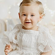 Matilda joined the competition — help win amazing prizes! baby, child, smiling, white_dress, plush_toy, bunny, barefoot, portrait, indoor, soft_lighting, cute, happy, infant, sitting, fairy_lights, blonde_hair, closeup, adorable, gentle, soft_texture