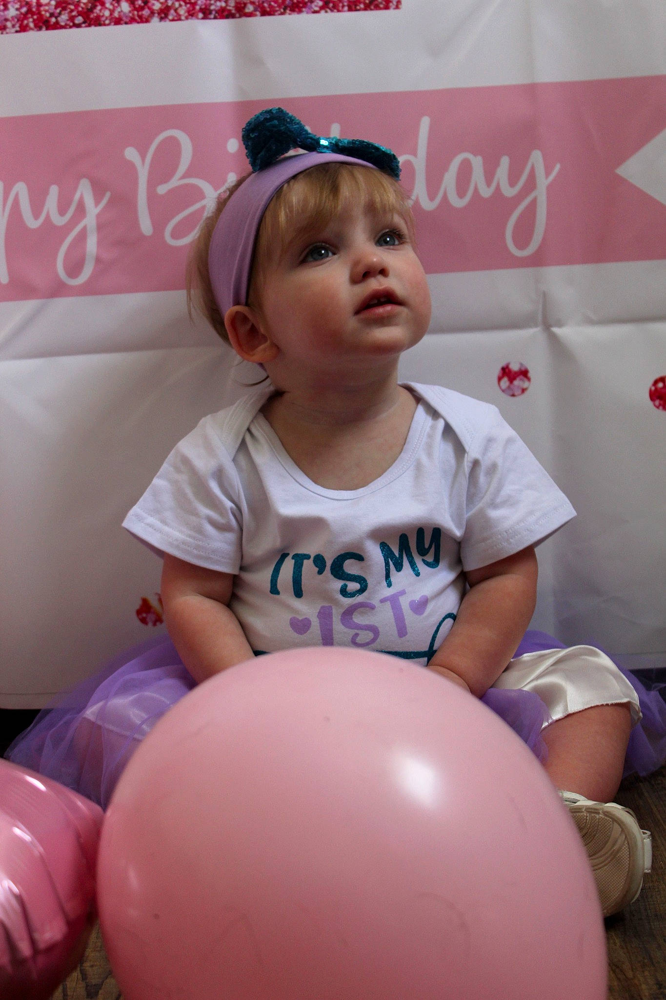 Jacklynn is registered to the contest to win money with this photo: baby_toddler_clothing, balloon, beauty, child, event, face, facial_expression, fun, happy, leisure, logo, magenta, party_supply, person, pink, recreation, sitting, sleeve, t_shirt, thigh
