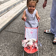 Ambre participe au concours pour gagner de l'argent avec cette photo : casual_clothing, child, daytime, girl, grass, hand, happy, outdoor, pavement, person, pigtails, play, sandal, smile, steps, striped_pants, stuffed_animal, summer, toy_stroller, walking