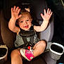toddler, car_seat, child, pink_shoes, smiling, hands_up, hair_clip, seat_belt, vehicle_interior, cute, happy, safety, infant, casual_clothing, playful, baby, car, seat, footwear, expression