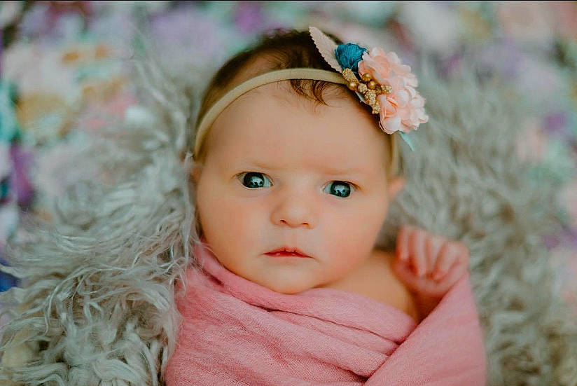 Haisley is registered to the contest to win money with this photo: baby, baby_toddler_clothing, eyelash, face, flash_photography, flower, grass, happy, headband, headgear, headpiece, iris, jewellery, lip, magenta, person, petal, pink, plant, skin
