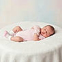 Vicky is registered to the contest to win money with this photo: baby, newborn, sleeping, infant, pink_clothing, white_blanket, soft_texture, peaceful, cute, resting, child, portrait, indoors, cozy, small, human, adorable, peace, relaxed, lying_down