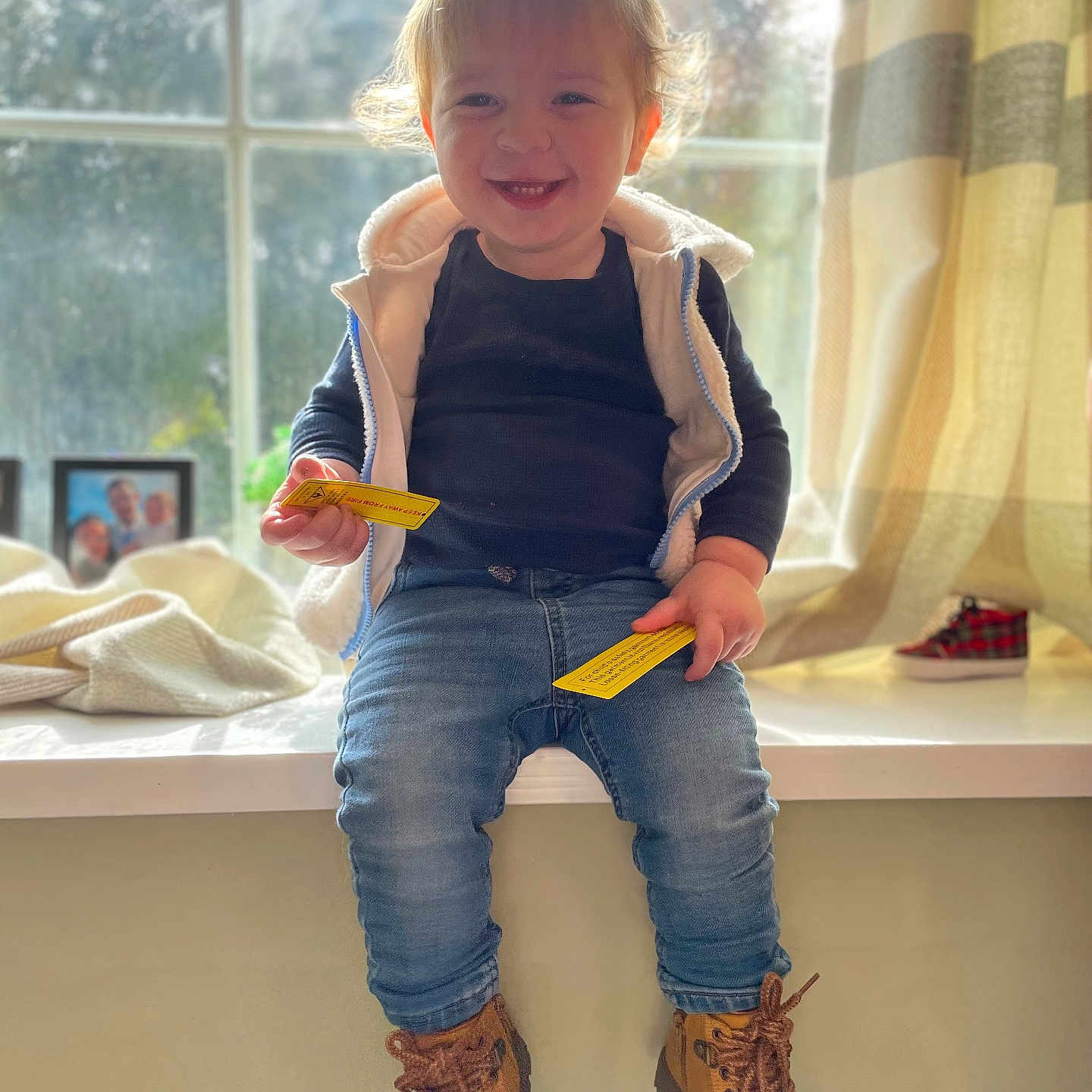 Greyson is registered to the contest to win money with this photo: boy, child, clothing, costume, creditcard, face, footwear, head, jeans, male, pants, person, photoframe, photography, portrait, shoe, sitting, sneaker, text, window