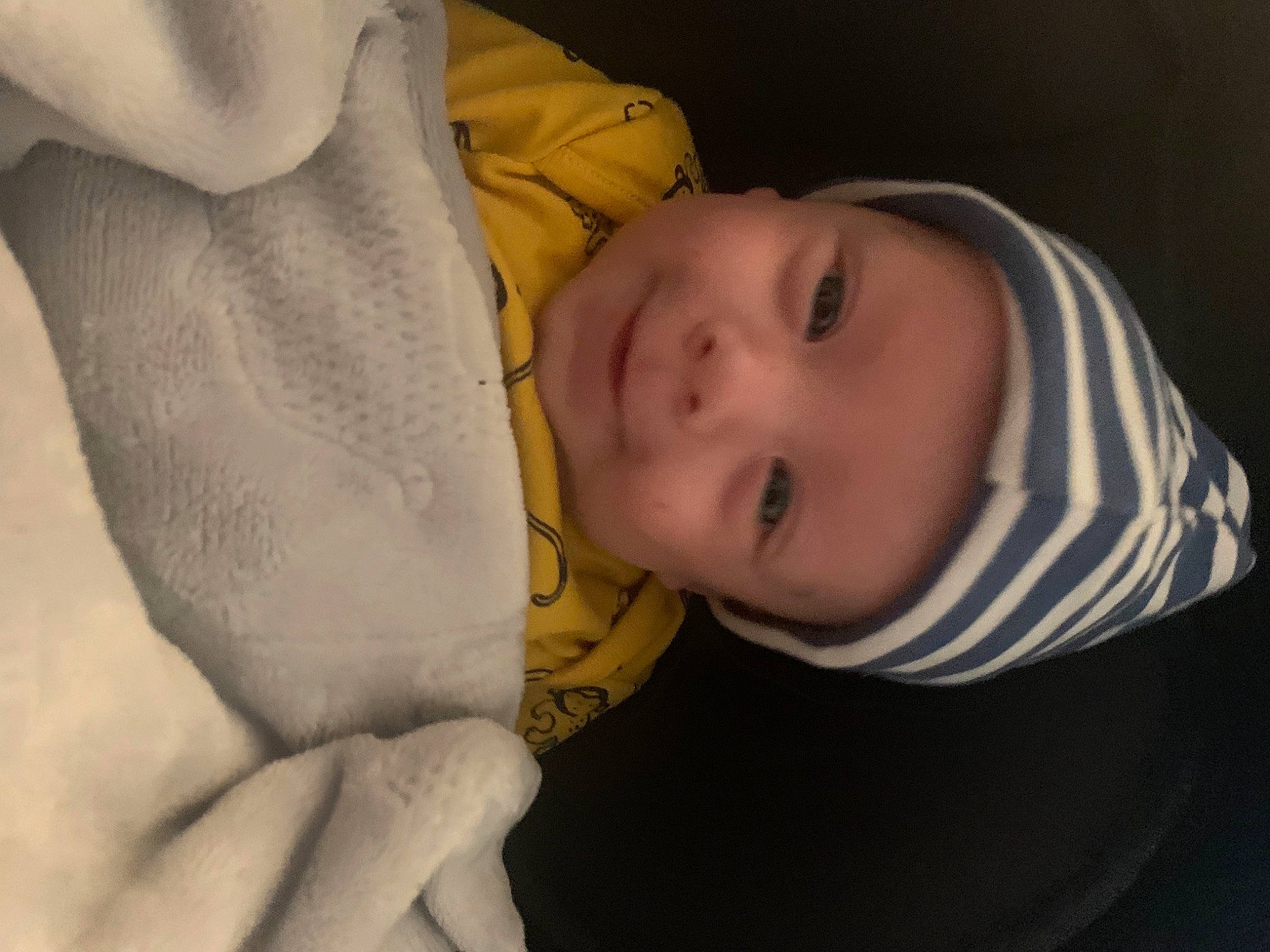 Ernie is registered to the contest to win money with this photo: baby, baby_toddler_clothing, cheek, child, comfort, eye, eyelash, finger, gesture, happy, headwear, iris, linens, lip, mouth, nose, person, skin, sleeve, smile