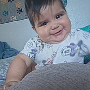Renata joined the competition — help win amazing prizes! baby, bed, bedding, blanket, cartoon_print, child, clothing, cozy, eyes, face, hair, happy, head, home, indoor, infant, onesie, portrait, rug, smiling