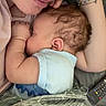 baby, adult, sleeping, glasses, bracelet, blanket, remote_control, closeup, resting, comfort, couch, arm, skin, head, person, indoor, family, toddler, relaxation, nap