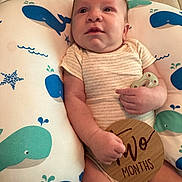 Cj joined the competition — help win amazing prizes! baby, infant, cushion, whale_pattern, wooden_sign, pacifier, clothing, lying_down, cute, child, person, skin, face, hand, expression, indoor, soft_lighting, newborn, milestone, background