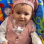 baby, child, infant, pink_outfit, chef_hat, bow_tie, baby_seat, colorful, animal_print, cute, smiling, portrait, sitting, indoors, clothing, face, person, young_child, happy, comfortable