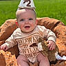 baby, child, infant, smiling, hat, birthday_hat, plush_toy, orange_blanket, outdoor, green_field, blue_sky, happy, cute, sitting, clothing, face, person, sunlight, portrait, celebration