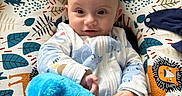 Adriano participe au concours pour gagner de l'argent avec cette photo : baby, child, colorful, comfort, cushion, cute, cute_expression, fabric, face, hand, indoors, infant, lion_pattern, pajamas, person, playful, plush_toy, portrait, smile, soft_toy