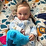 baby, child, colorful, comfort, cushion, cute, cute_expression, fabric, face, hand, indoors, infant, lion_pattern, pajamas, person, playful, plush_toy, portrait, smile, soft_toy