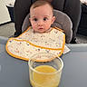 Adriano a rejoint le concours — aidez-le/la à gagner de superbes lots ! baby, bib, child, clothing, curious, expression, face, feeding, furniture, glass, high_chair, indoor, kitchen, modern, orange_juice, person, plant, table, tray, young_child