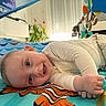 Adriano participe au concours pour gagner de l'argent avec cette photo : baby, child, clothing, colorful, cozy, curious, cute, eyes, face, floor, hand, happy, head, indoor, infant, long_sleeve, pants, play_mat, smiling, toy