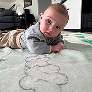 Adriano a rejoint le concours — aidez-le/la à gagner de superbes lots ! baby, cabinet, child, clothing, curious, dartboard, face, floor, furniture, home, indoor, infant, lying_down, pants, pattern, person, portrait, rug, sofa, sweater