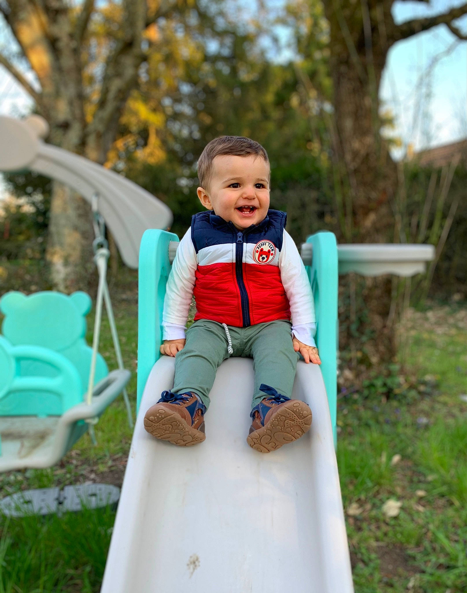 Nino a rejoint le concours — aidez-le/la à gagner de superbes lots ! baby, baby_toddler_clothing, chute, dress, electric_blue, eye, grass, happy, joy, leisure, outdoor_play_equipment, people_in_nature, person, plant, playground, playground_slide, recreation, smile, swing, t_shirt