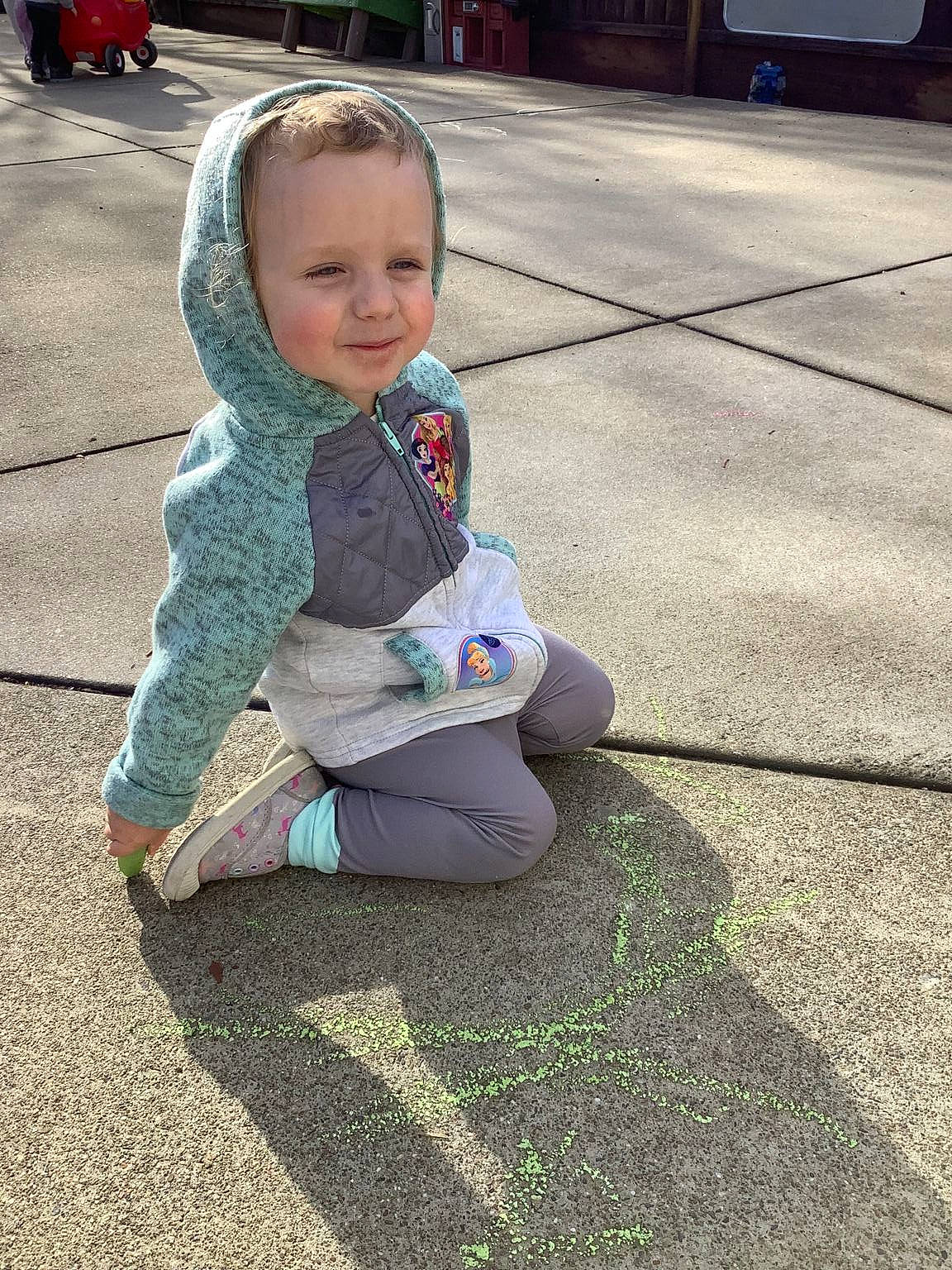 Penny is registered to the contest to win money with this photo: asphalt, baby, baby_toddler_clothing, child, city, flooring, foot, grass, head, human_leg, leaf, leisure, person, play, recreation, road, road_surface, sidewalk, sitting, smile